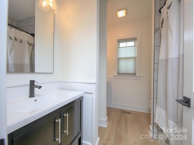 bathroom with hardwood / wood-style flooring, vanity, and a shower with curtain