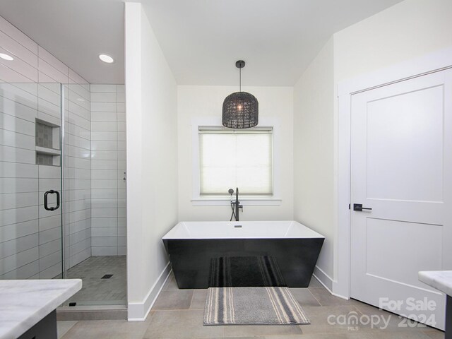 bathroom with tile patterned flooring, shower with separate bathtub, and vanity