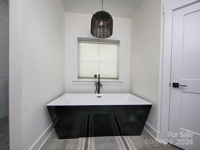 bathroom with tile patterned flooring and a bath