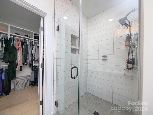 bathroom featuring wood-type flooring and walk in shower