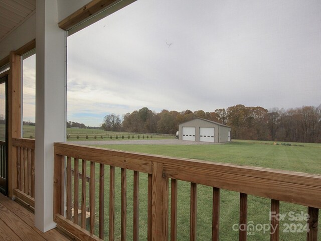 exterior space with an outbuilding, a rural view, a garage, and a deck