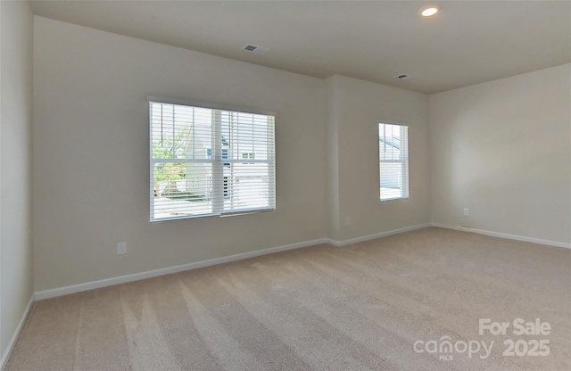 unfurnished room featuring light colored carpet