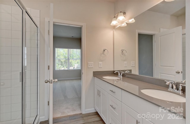 bathroom with hardwood / wood-style flooring, vanity, and a shower with shower door