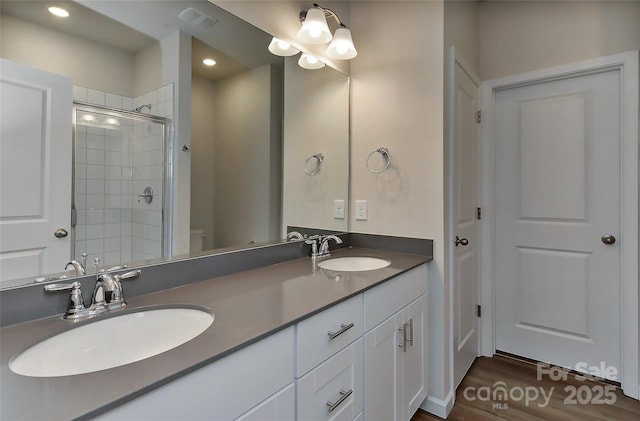 bathroom featuring vanity, a shower with door, toilet, a notable chandelier, and wood-type flooring