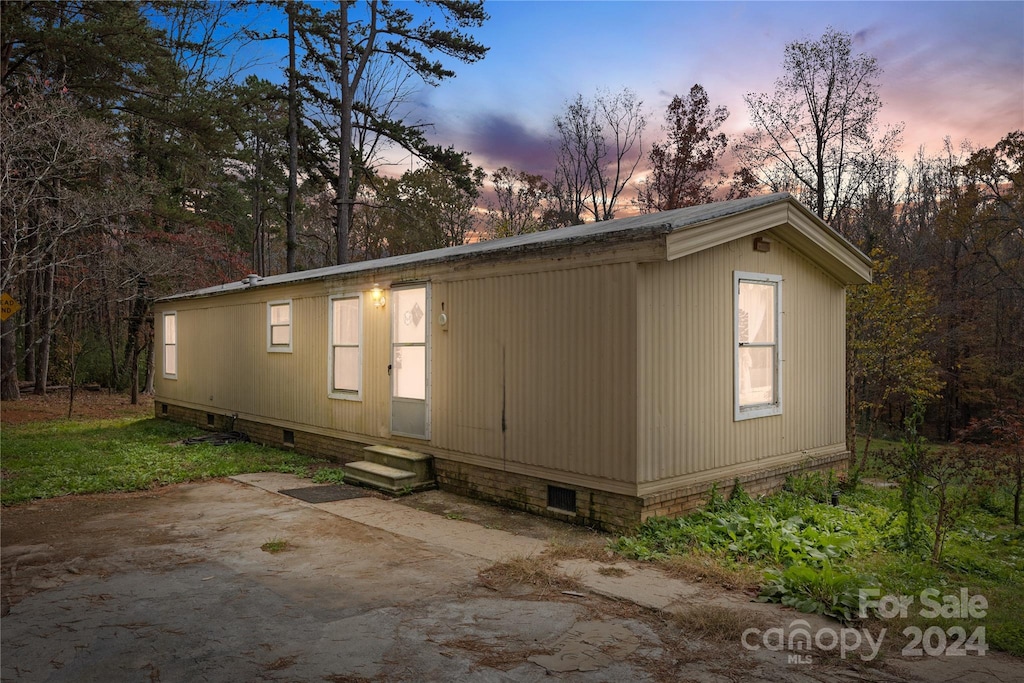 back house at dusk featuring a patio