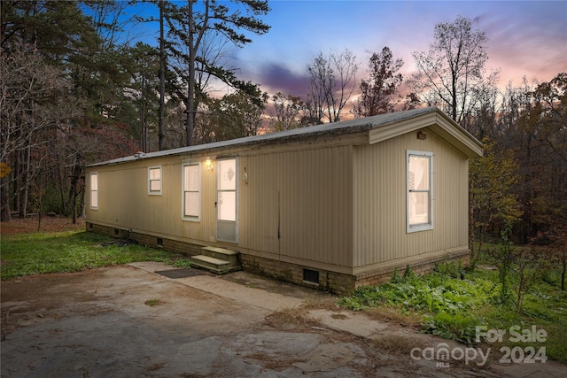 back house at dusk featuring a patio