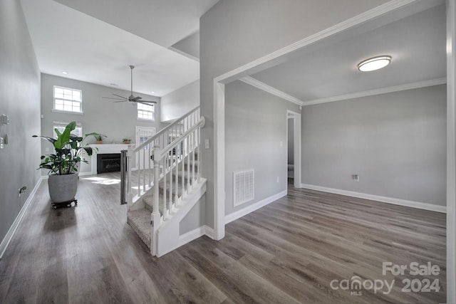 staircase featuring hardwood / wood-style flooring, ceiling fan, and crown molding