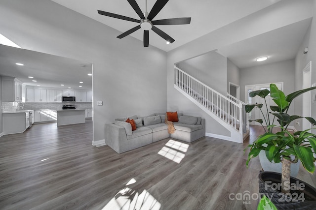 living room featuring ceiling fan, sink, and hardwood / wood-style flooring