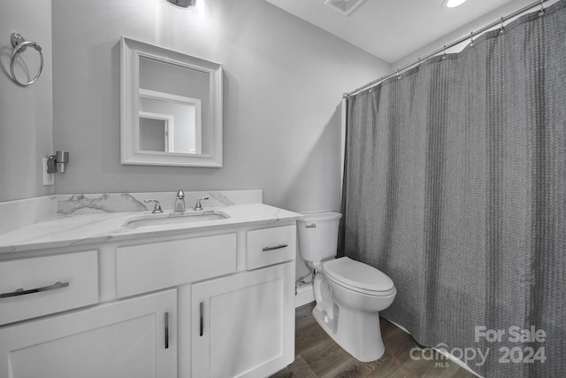 bathroom featuring hardwood / wood-style flooring, vanity, curtained shower, and toilet