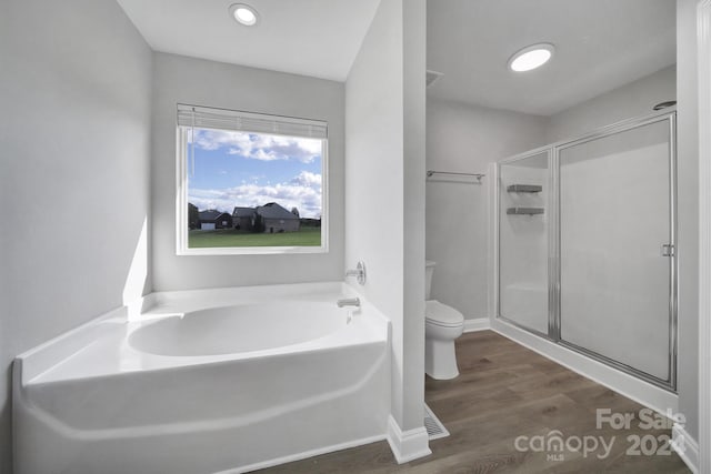 bathroom with toilet, wood-type flooring, and plus walk in shower