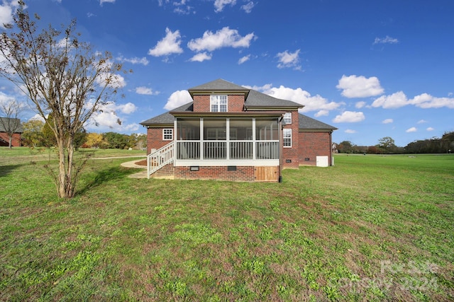 rear view of house with a sunroom and a lawn