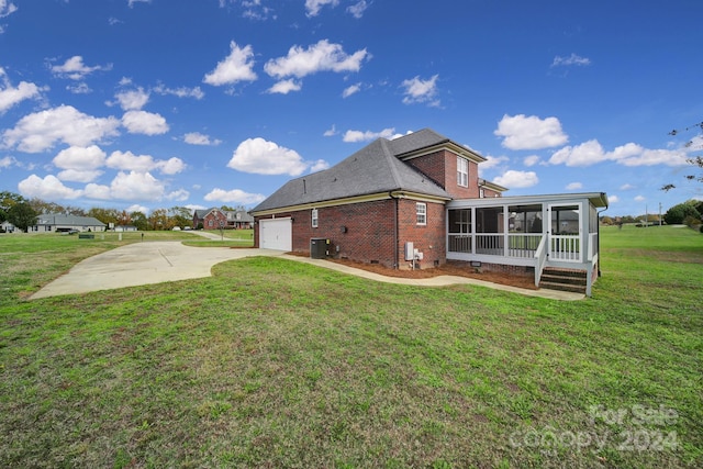 view of property exterior featuring a sunroom, a garage, and a yard