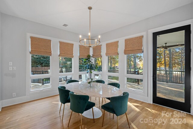 dining room with light hardwood / wood-style floors and a chandelier