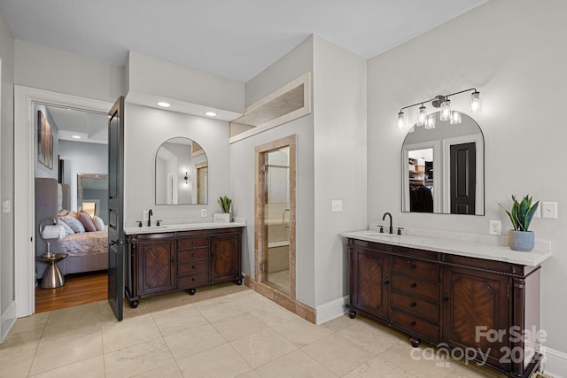 bathroom with tile patterned flooring, vanity, and walk in shower