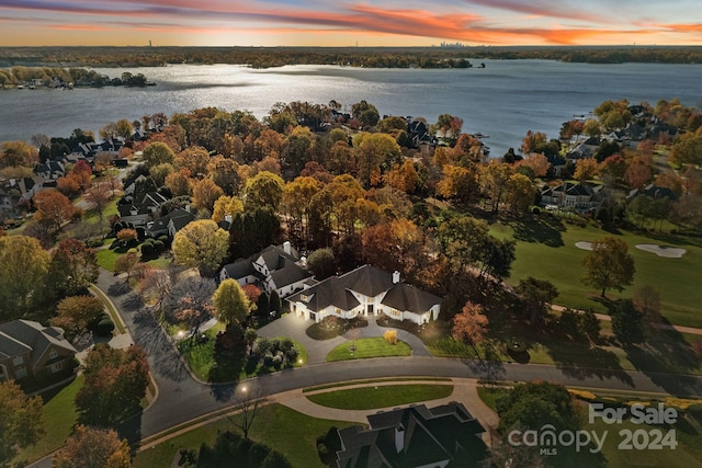 aerial view at dusk featuring a water view