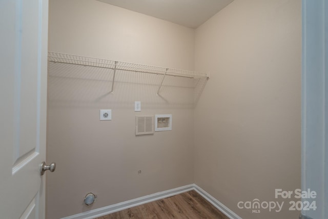 clothes washing area with hookup for an electric dryer, hookup for a washing machine, and hardwood / wood-style flooring