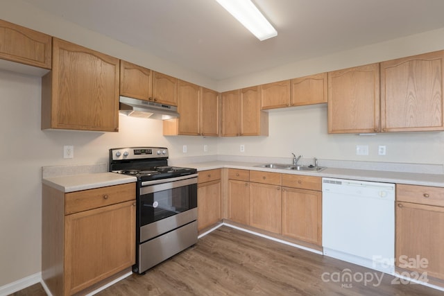 kitchen with dishwasher, sink, light brown cabinetry, stainless steel range with electric cooktop, and hardwood / wood-style flooring