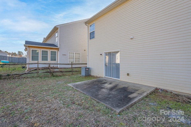 back of house featuring a lawn and a patio