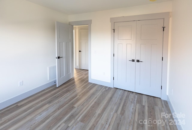 unfurnished bedroom featuring light wood-type flooring and a closet