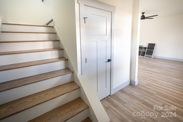 stairway featuring ceiling fan and hardwood / wood-style flooring