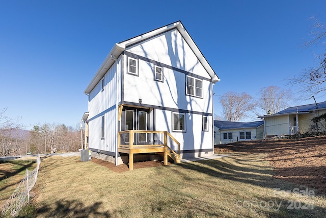 rear view of property featuring a lawn