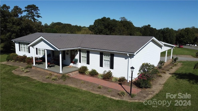 single story home featuring a porch and a front yard