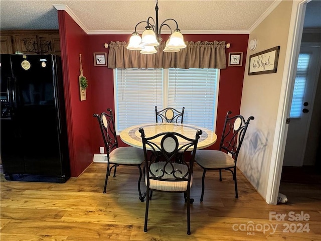 dining area with crown molding, light hardwood / wood-style flooring, a textured ceiling, and an inviting chandelier