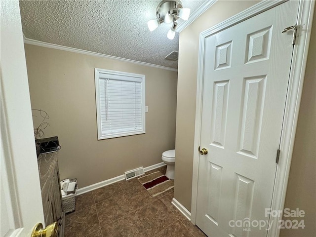 bathroom with crown molding, tile patterned flooring, a textured ceiling, and toilet