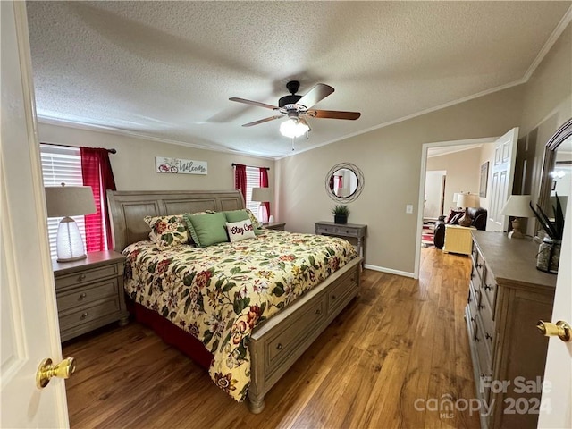 bedroom with hardwood / wood-style floors, ceiling fan, ornamental molding, and a textured ceiling