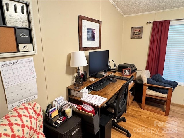 home office with a textured ceiling, light wood-type flooring, and crown molding