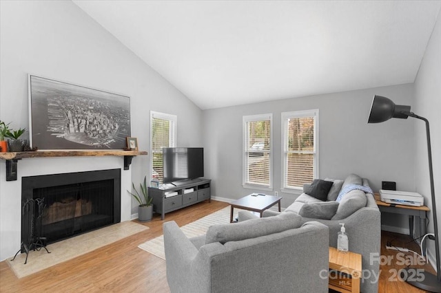 living room featuring lofted ceiling and light hardwood / wood-style flooring