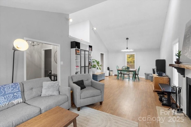 living room featuring wood-type flooring and high vaulted ceiling