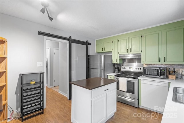 kitchen featuring sink, light hardwood / wood-style flooring, appliances with stainless steel finishes, a barn door, and white cabinets