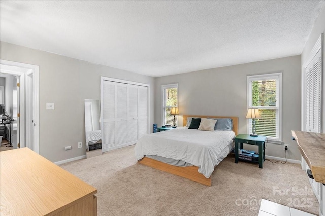 carpeted bedroom with a textured ceiling and a closet