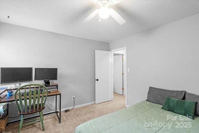 carpeted bedroom featuring ceiling fan and a textured ceiling