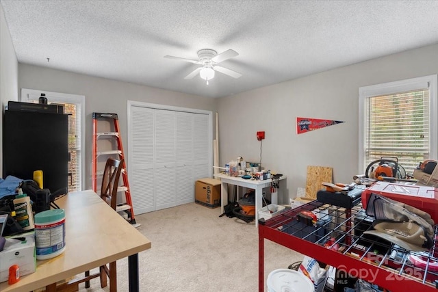 carpeted bedroom with ceiling fan, a textured ceiling, and a closet