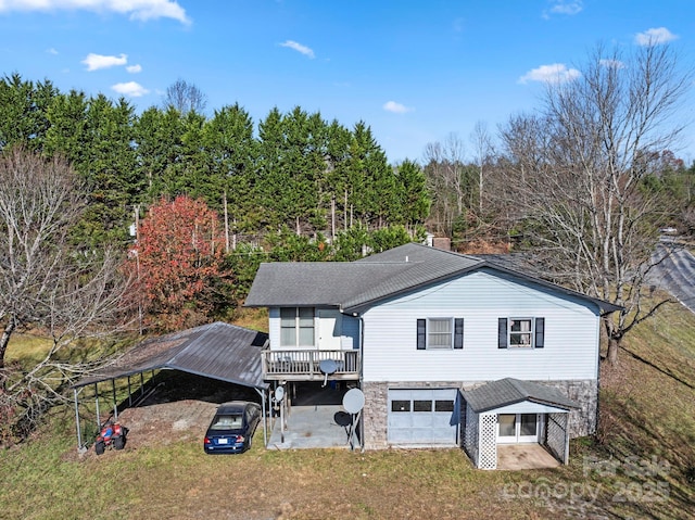 back of property featuring a deck and a garage