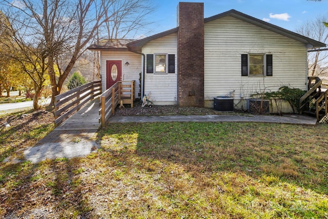 view of front of home featuring a front yard and central AC