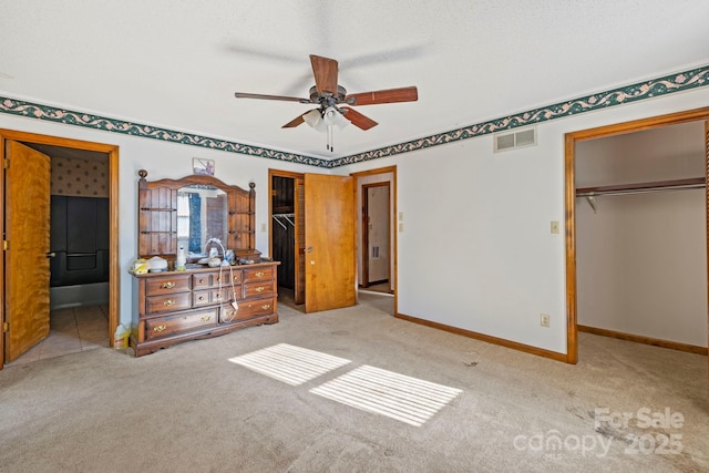 unfurnished bedroom with a textured ceiling, ceiling fan, and light carpet