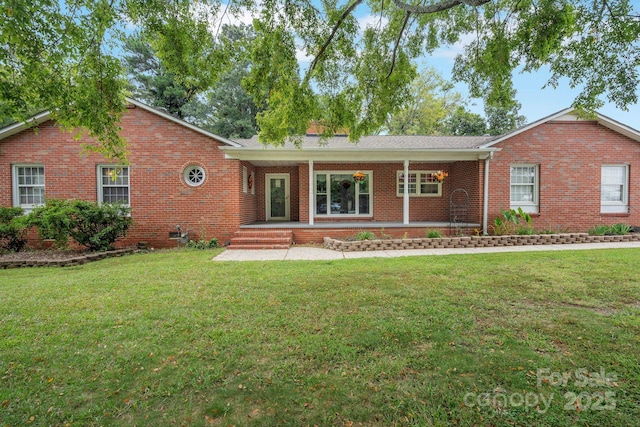 ranch-style home featuring covered porch and a front lawn