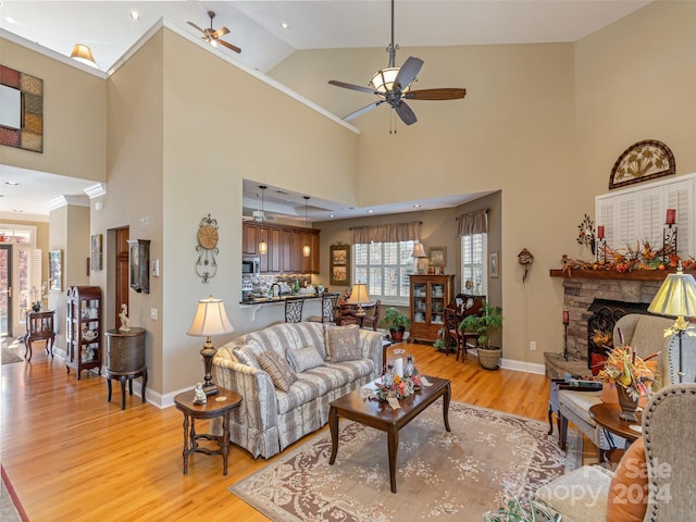 living room with a fireplace, light hardwood / wood-style floors, and high vaulted ceiling