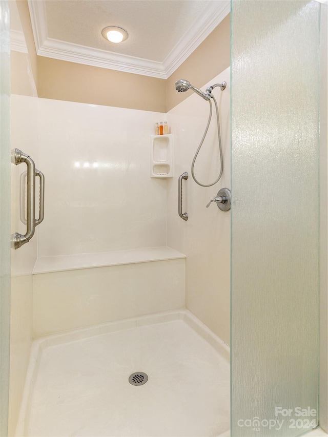 bathroom with an enclosed shower and ornamental molding