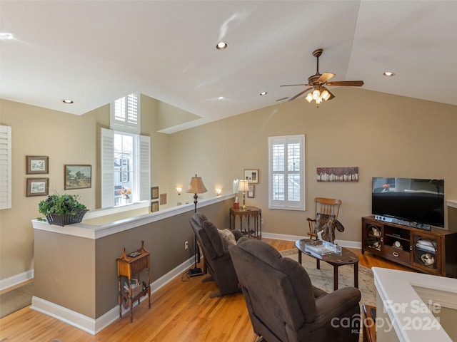 living room featuring ceiling fan, light hardwood / wood-style flooring, a healthy amount of sunlight, and vaulted ceiling