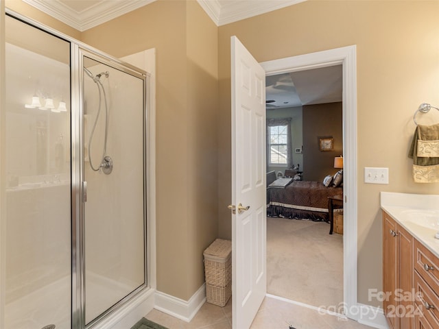 bathroom with crown molding, a shower with door, vanity, and tile patterned flooring