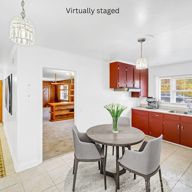 carpeted dining space featuring sink and a chandelier