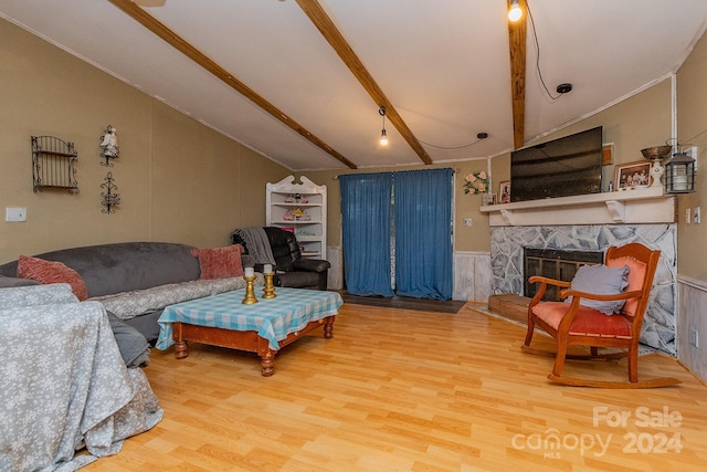 living room featuring vaulted ceiling with beams, a fireplace, and hardwood / wood-style flooring