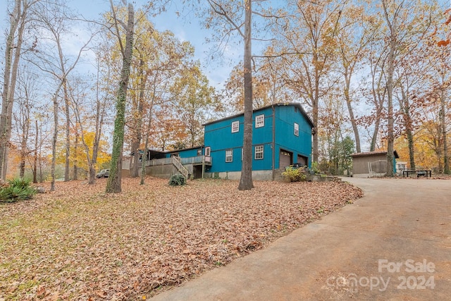 view of property exterior featuring a garage and a wooden deck