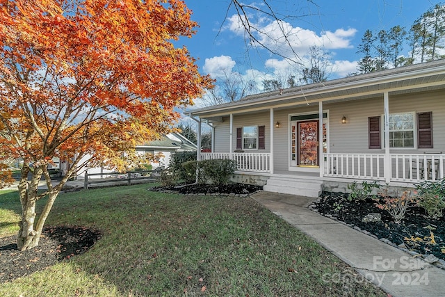 view of front of property featuring covered porch and a front yard