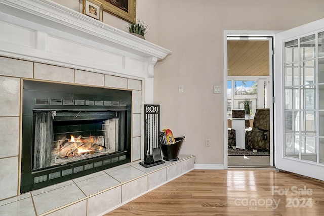 details with hardwood / wood-style flooring and a tile fireplace