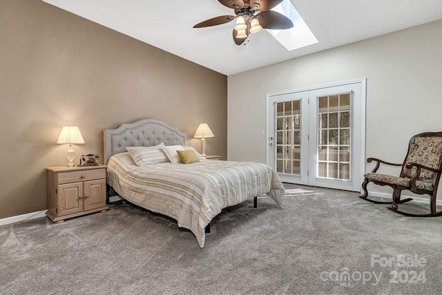 carpeted bedroom featuring access to exterior, ceiling fan, and a skylight